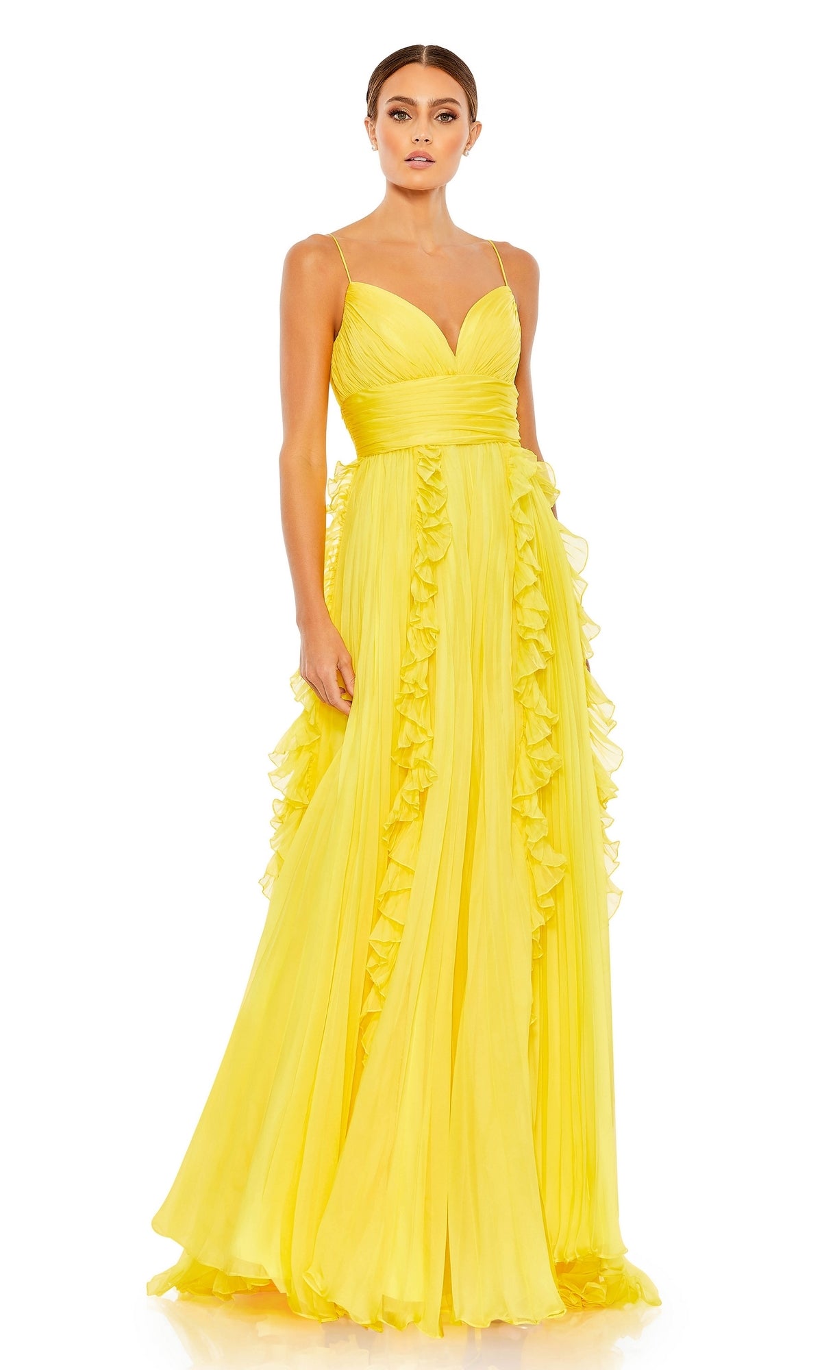 A woman stands wearing the Ruffled Long White Formal Dress 49533, featuring thin straps, a deep V-neckline, and ruffled detailing along its floor-length skirt.